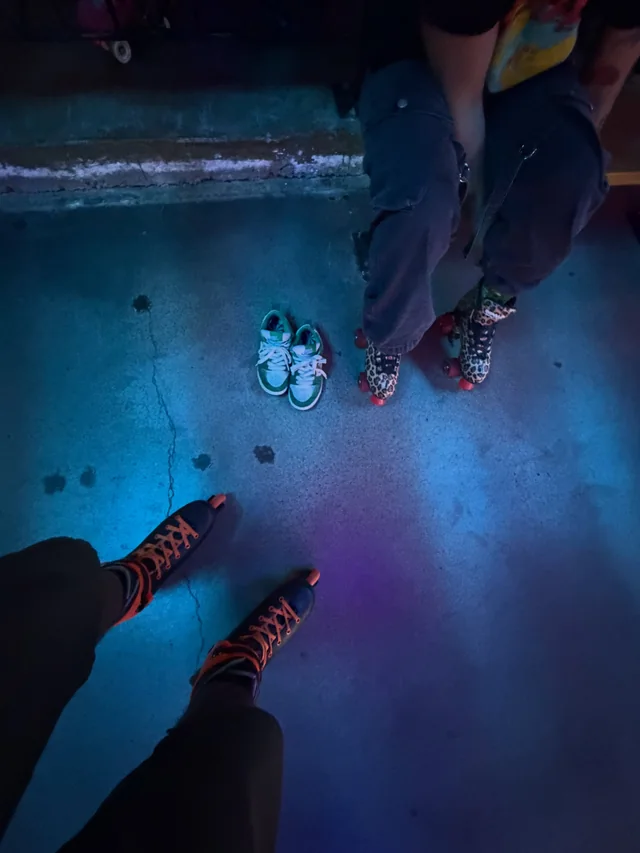 Shoes and legs on a blue-lit floor.