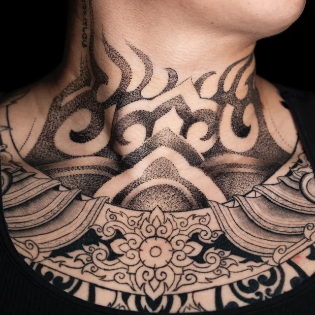 Angled view of the same front-neck ornament showing the flowing curls along one side.