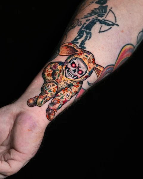 Wider view showing the matryoshka tattoo above the wrist. Artwork by William Martz.