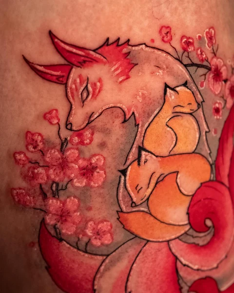 Close view of the foxes and cherry blossoms in the nine-tailed fox tattoo. Artwork by William Martz.
