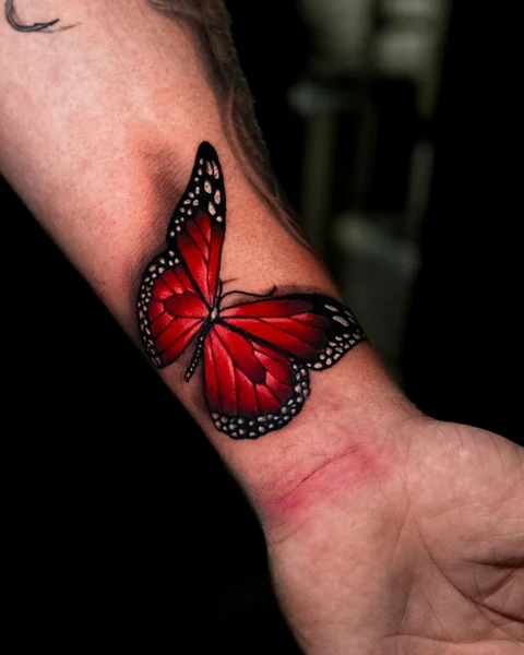 Wider wrist angle of the red butterfly tattoo. Artwork by William Martz.