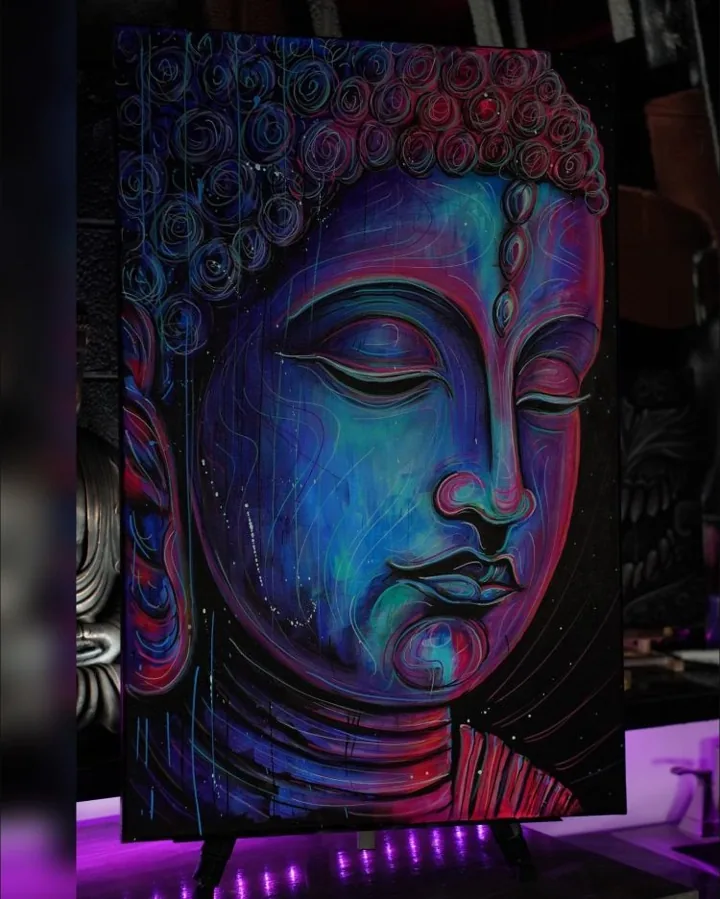 A painted Buddha portrait in blue, violet, and pink, with ornamental curls around the head.