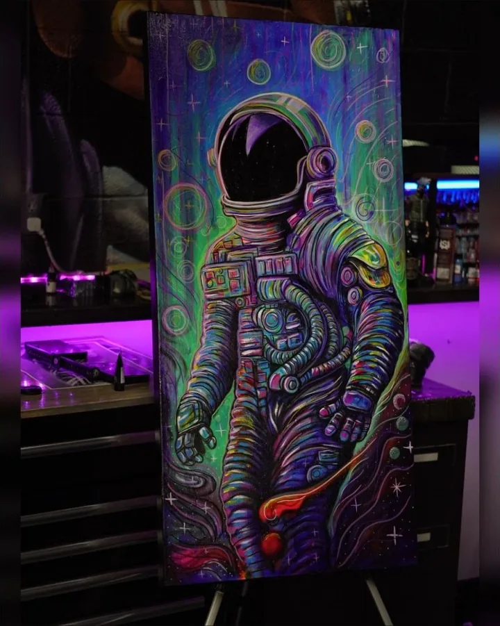 A colorful painting of an astronaut surrounded by circles, stars, and flowing lines.