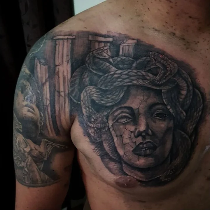 A black-and-gray Medusa portrait with snakes coiling around the head.