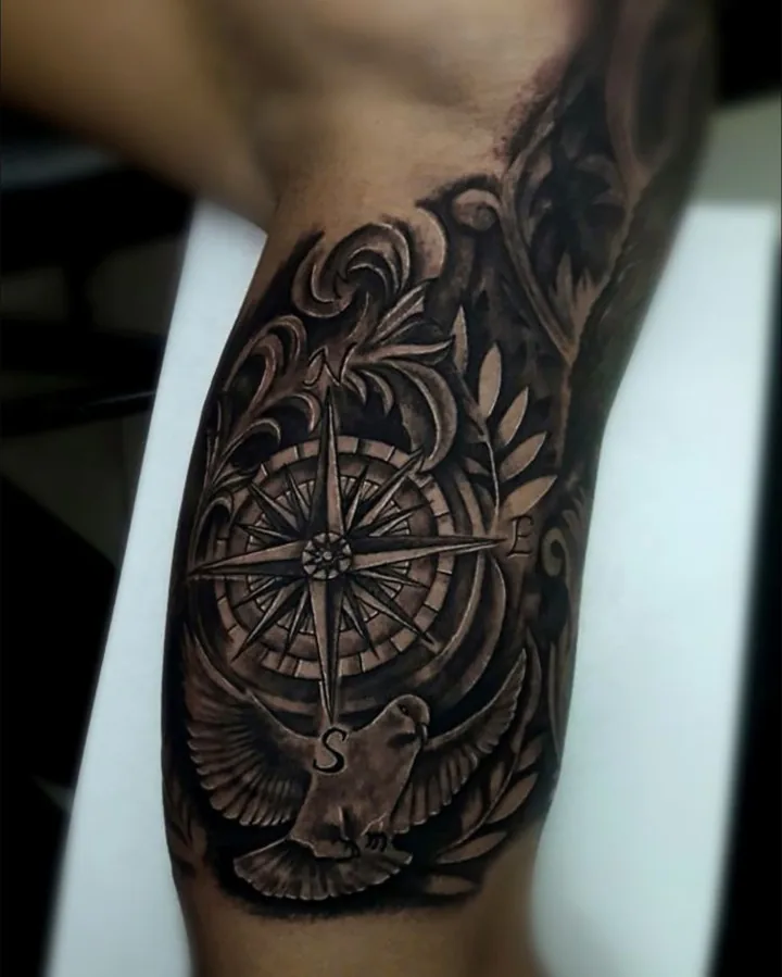 A black-and-gray compass composition with decorative leaves, curved borders, and fine directional marks.