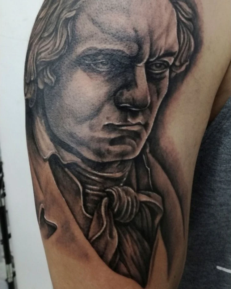 A black-and-gray portrait tattoo of Ludwig van Beethoven.