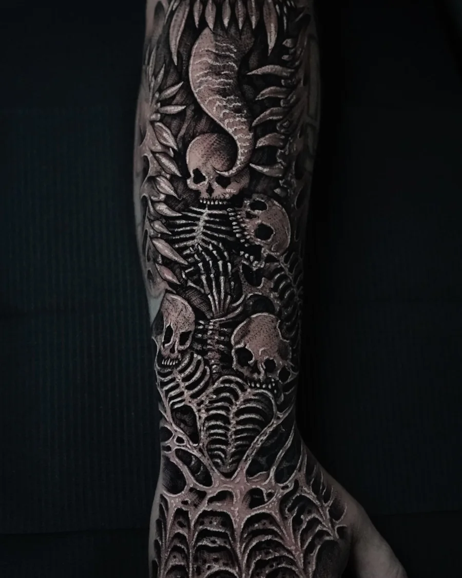 A black-and-gray ornamental composition extending along the forearm and onto the hand.