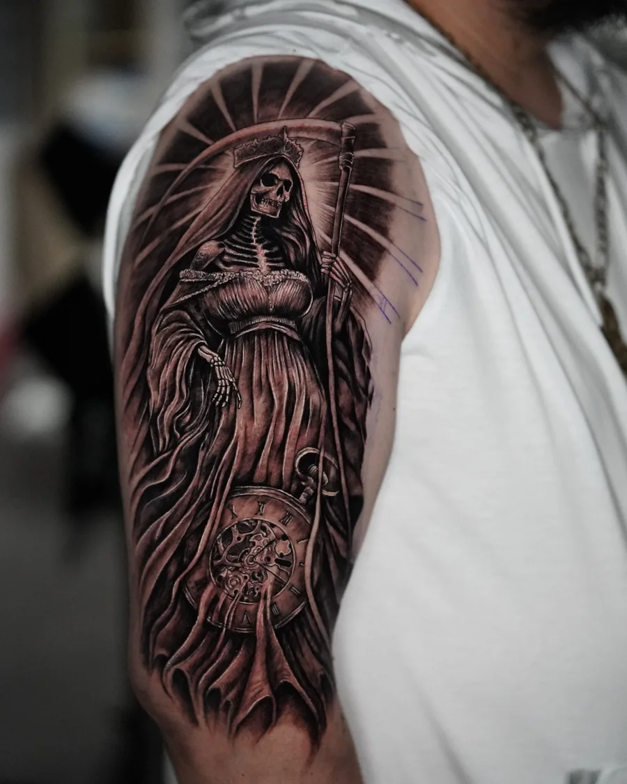 A robed female religious figure with a radiant halo and a clock face in a black-and-gray upper-arm tattoo.