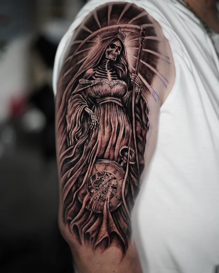 Alternate view. A robed female religious figure with a radiant halo and a clock face in a black-and-gray upper-arm tattoo.