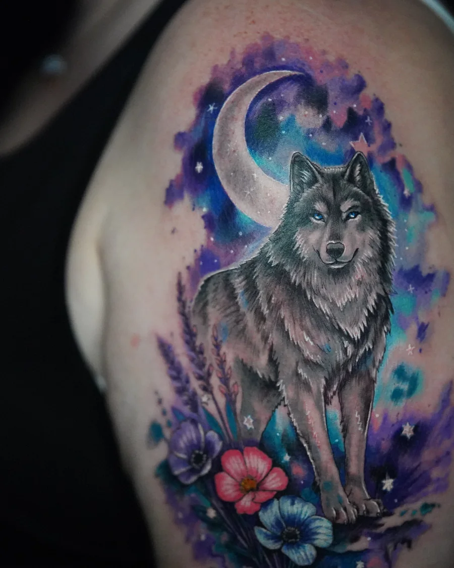 A wolf standing below a crescent moon, surrounded by purple and blue watercolor-like color and small flowers.