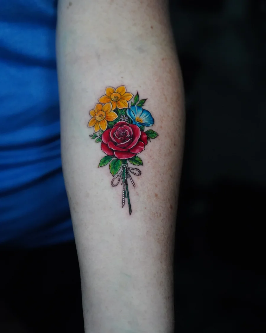 A small colorful bouquet of yellow, red and blue flowers with slender stems on the forearm.