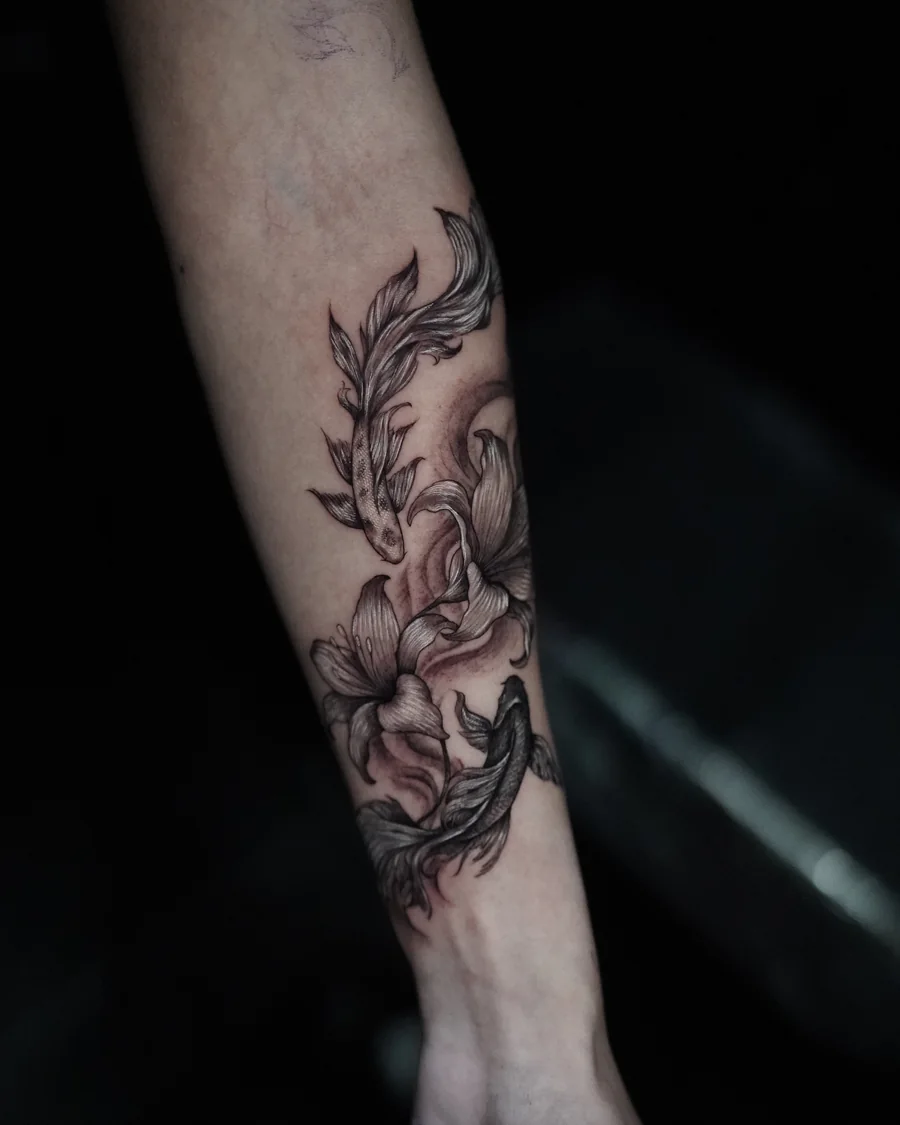 Large shaded blossoms and long flowing leaves arranged down the forearm in black and gray.