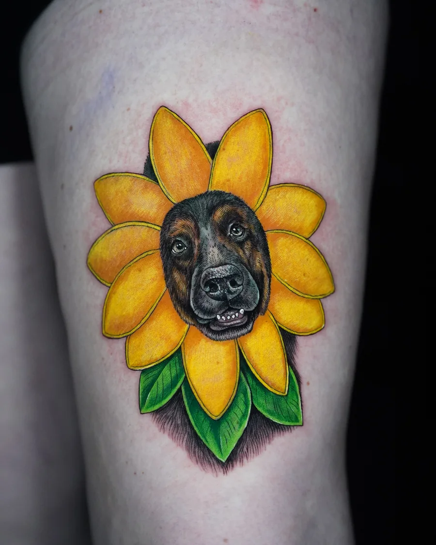 A black dog portrait at the center of a bright yellow sunflower with green leaves.