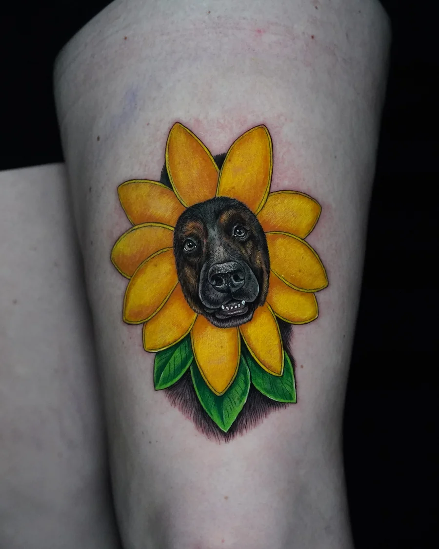 Alternate view. A black dog portrait at the center of a bright yellow sunflower with green leaves.
