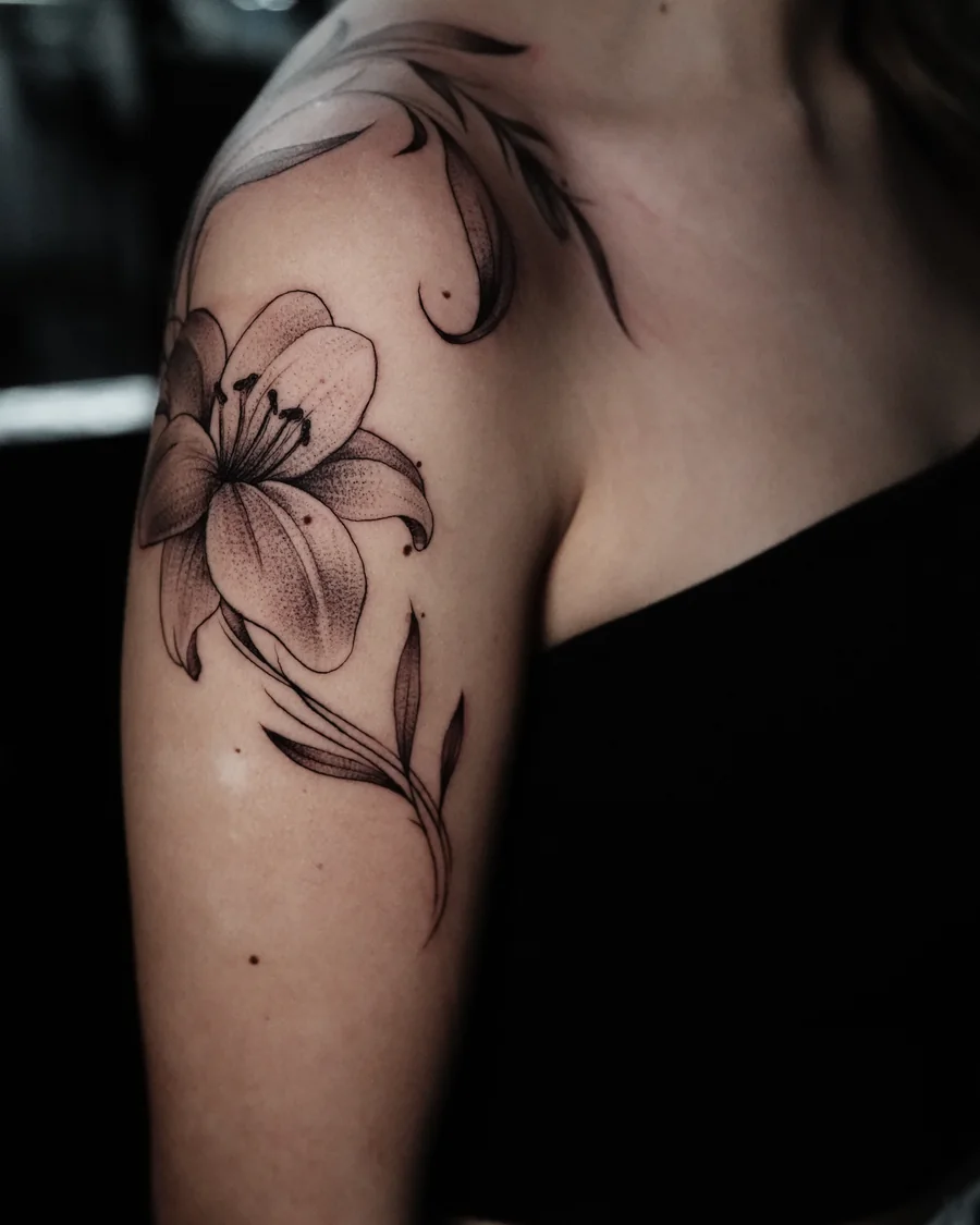 Alternate view. Large fine-line lilies and flowing leaves extending over the shoulder and toward the collarbone.