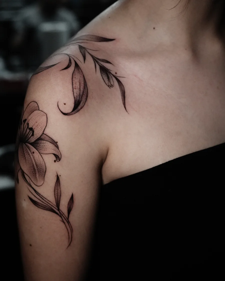 Alternate view. Large fine-line lilies and flowing leaves extending over the shoulder and toward the collarbone.