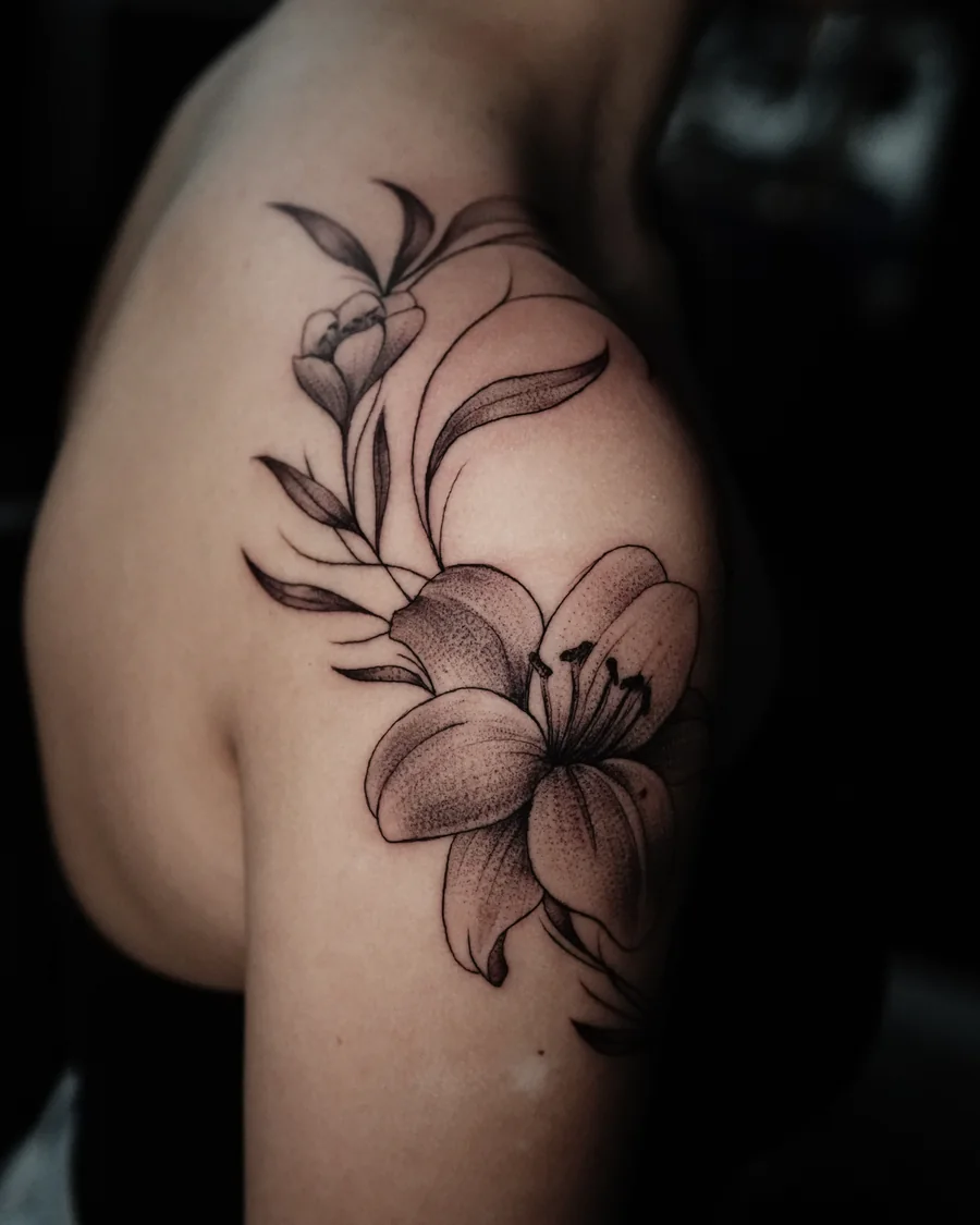 Alternate view. Large fine-line lilies and flowing leaves extending over the shoulder and toward the collarbone.