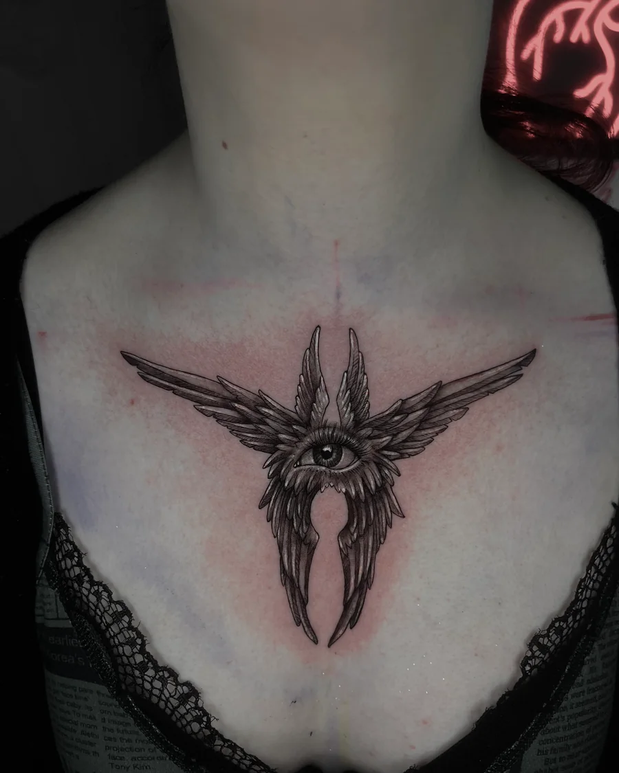 An ornamental eye with radiating feather-like wings and pointed forms across the upper chest.