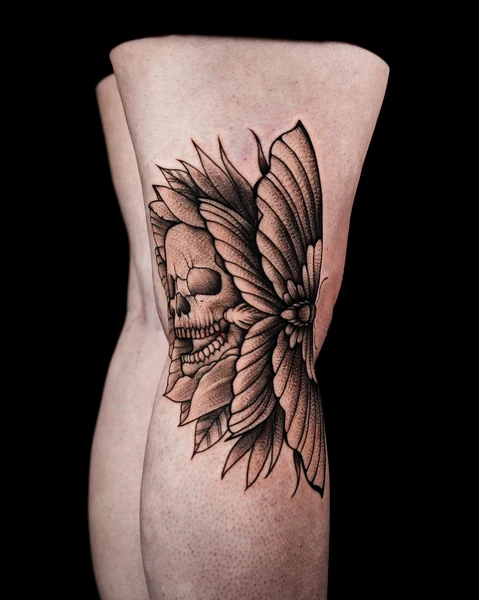 A forearm tattoo combining a skull with a large sunflower in black and gray.